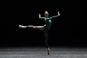 A single dancer in a promotional image from "rEVOLUTION" at Boston Ballet