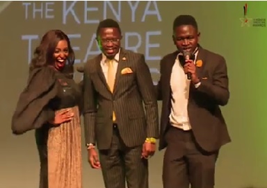The ceremony hosts, Kelly Kagiri (left) and Brian Aseli (right) pose with Cabinet Secretary Ababu Namwamba. 