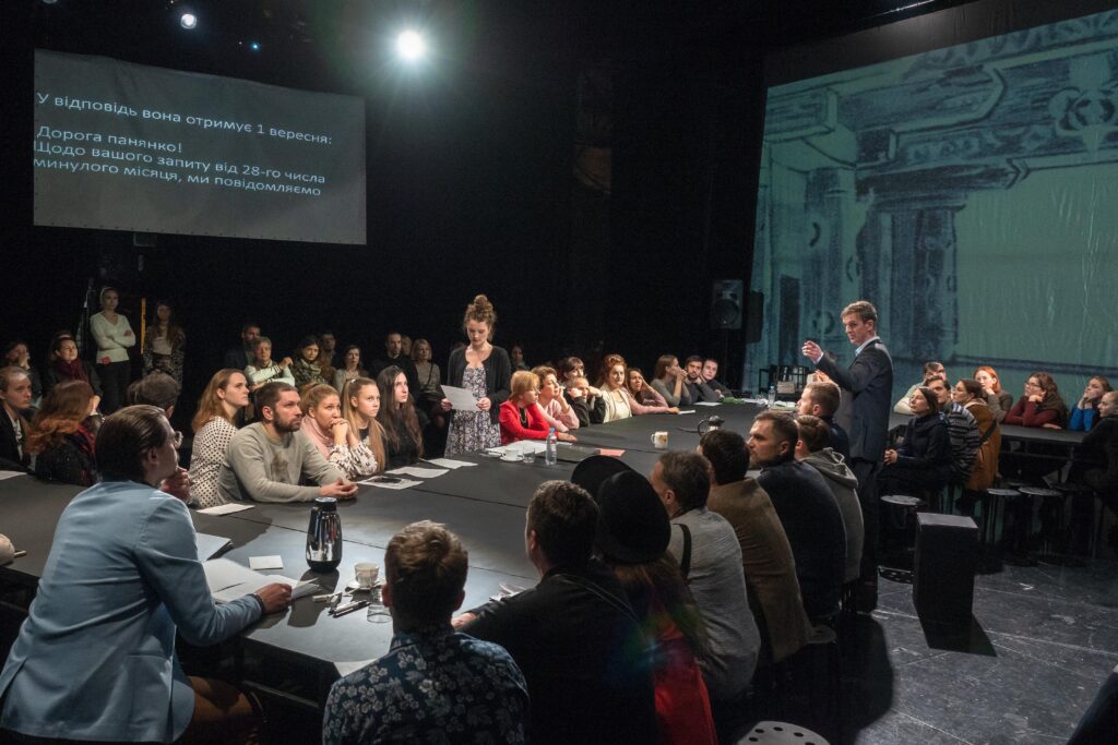 Artists and audience intermingle at a performance of <em>Solpersteine Staatstheater</em>, directed by Hans-Werner Kroesinger and Regine Dura, at the Kyiv Academic Molodyy Theatre, December 2018. (Photo credit: Oleksii Tovpyha)