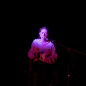 An actress peering through the darkness onstage
